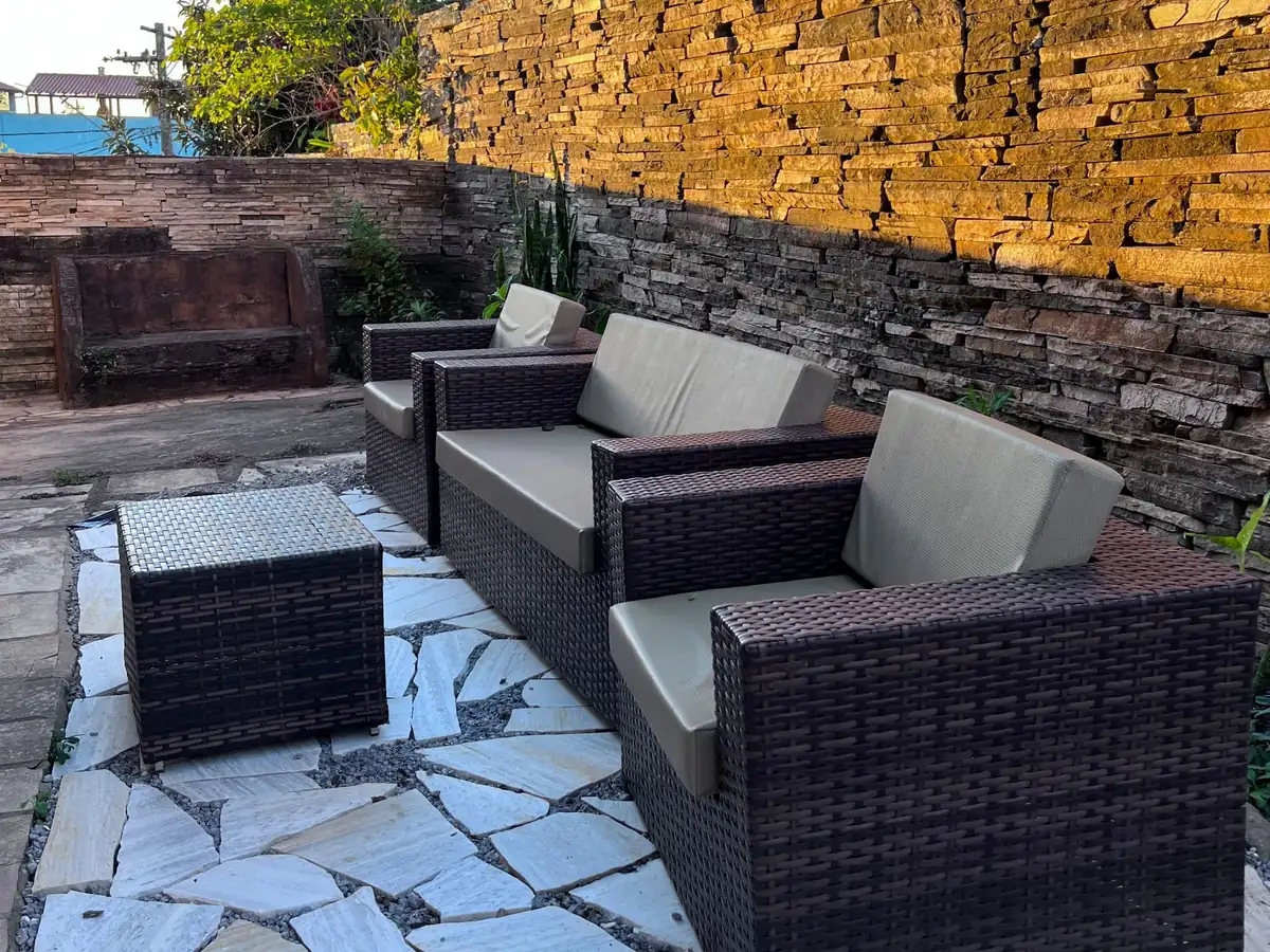 Pátio com sofás e muro de pedra